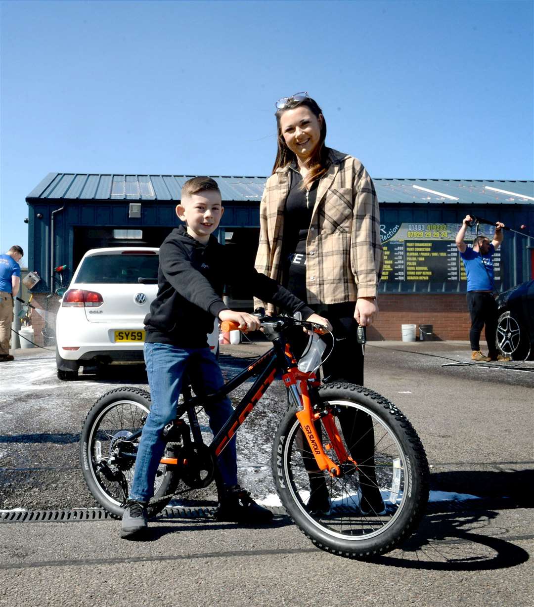 SR Reflection charity car wash..Aiden Butchart on the bike he's received from SR Reflection, with his mum, Danika Keogh..Picture: James Mackenzie..